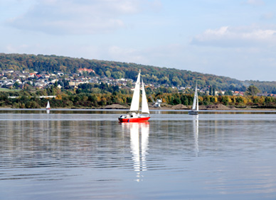 Segelboote auf dem Northeimer Freizeitsee: Im Hintergrund Kiesgewinnung mit dem landgestützten Eimerkettenbagger